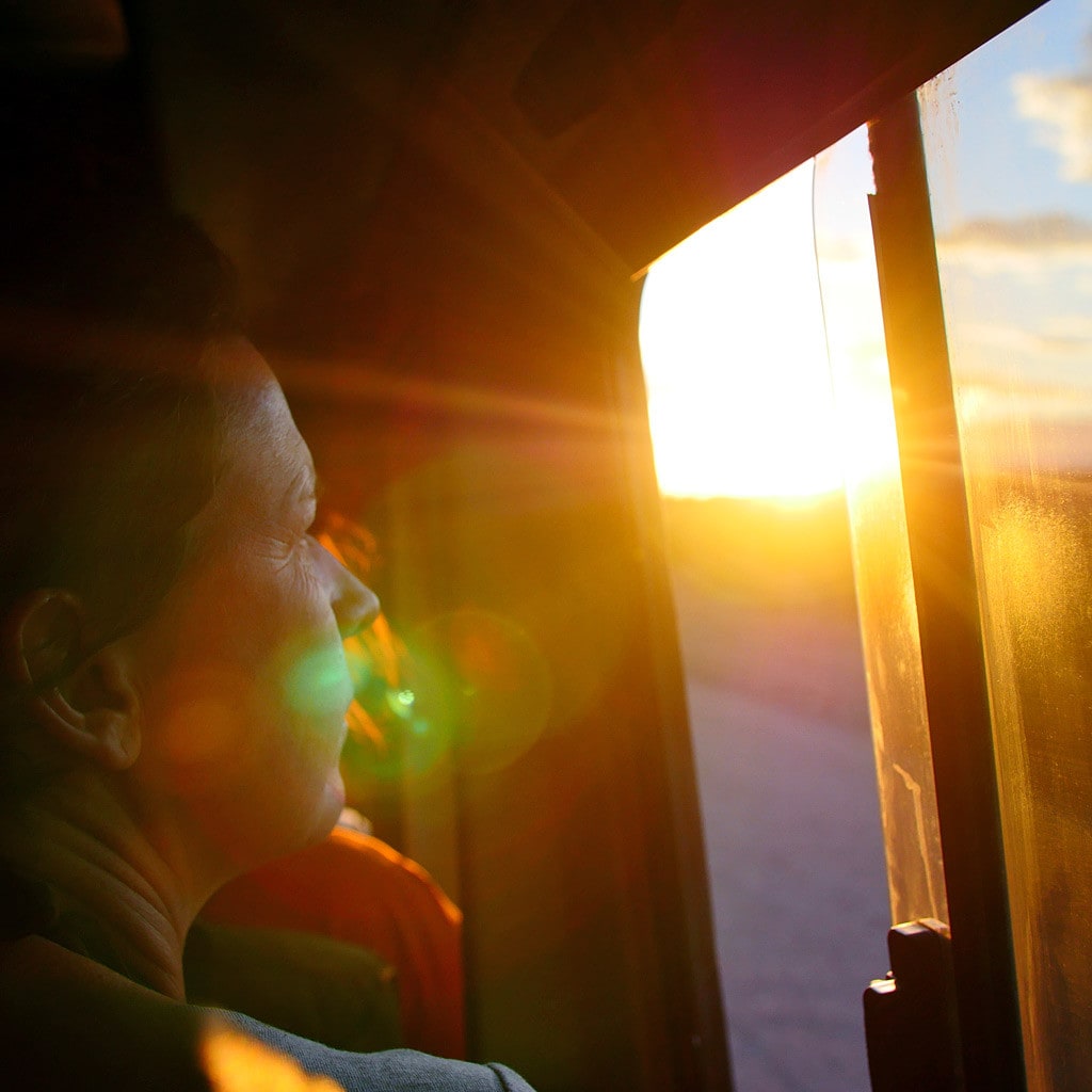 Eine Frau schaut aus dem Safariauto während einer Camping Safari in Namibia